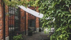 Un edificio de ladrillo con terraza y plantas en macetas.