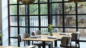 Un restaurante con amplios ventanales, mesas y sillas.