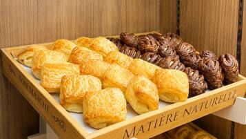Un expositor de madera con pasteles etiquetados 'BON MARCHÉ' y 'MATIÈRE NATURELLLE'.