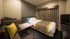 A hotel room with a bed, a sofa, a small table, a TV, and a wall with a geometric pattern. - Almont Inn Nihonbashi (Tokyo)