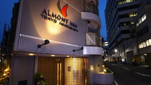 A hotel entrance with a tiled facade, a prominent logo, and a gated entrance. - Almont Inn Nihonbashi (Tokyo)