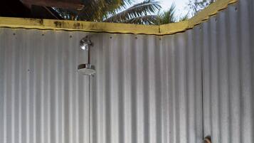 Una pared de metal corrugado con dos elementos metálicos, uno con una abertura circular y otro con malla de alambre.