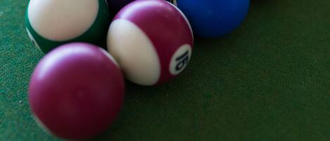 A close-up of a pool table with various colored billiard balls.
