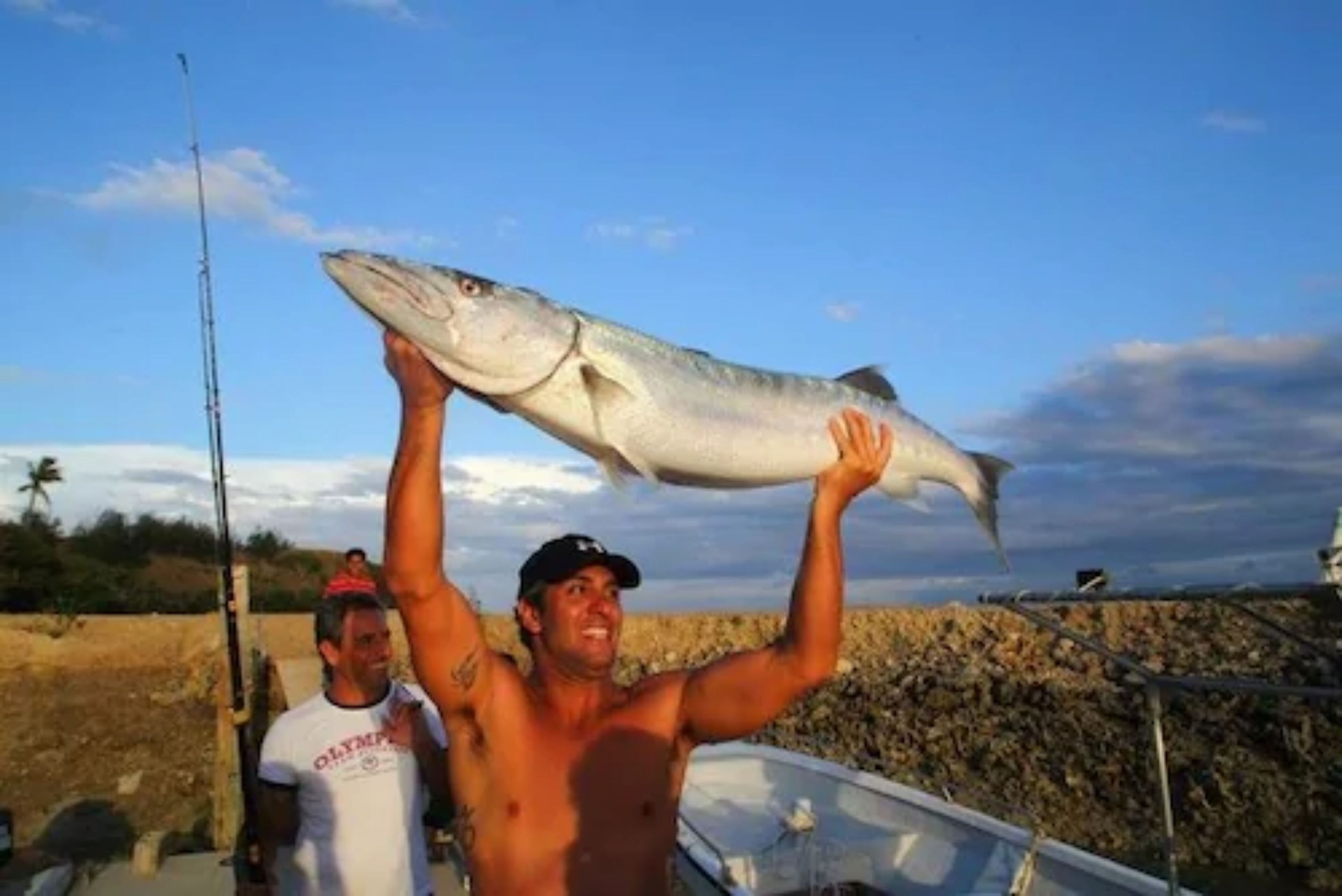 A man holding a large fish above his head.