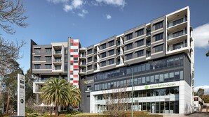 A multi-story building with a modern architectural design, featuring balconies and large windows. - Punthill Norwest (Norwest)