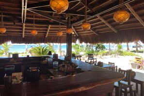 A beachside bar with a thatched roof, wooden furniture, and a view of the ocean. - Levantin (Boracay Island)