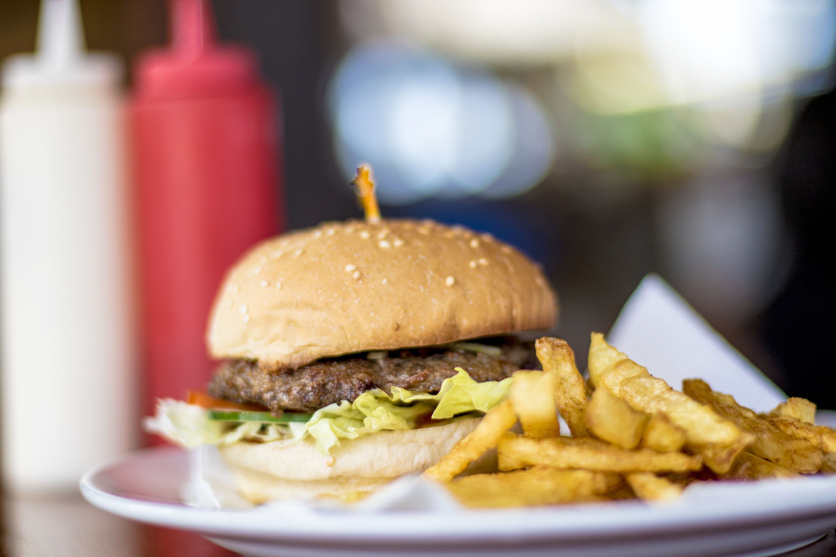 Un hamburger accompagné de frites, servi sur une assiette.