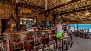 A bar area with wooden furniture and a thatched roof. - Levantin (Boracay Island)