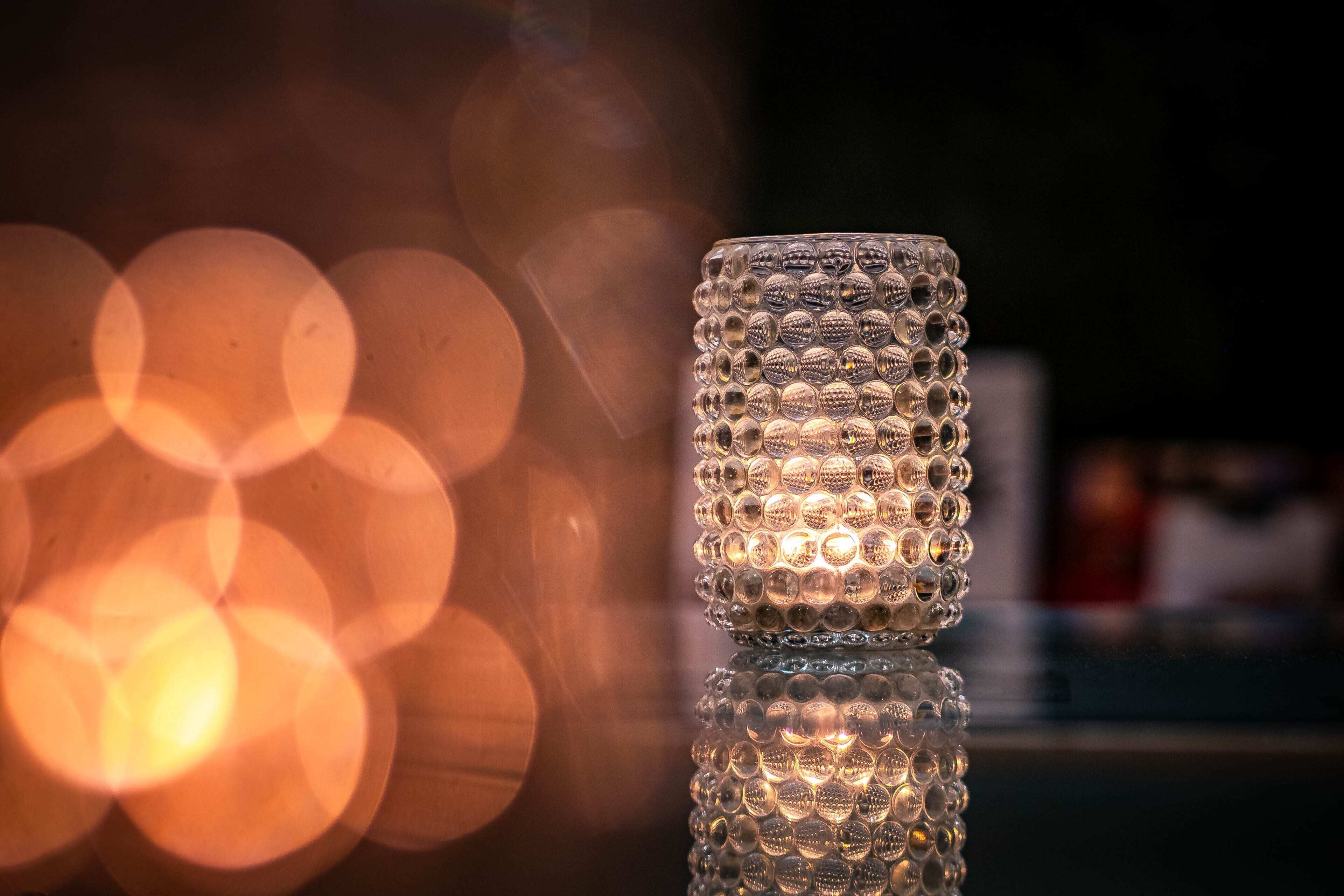 A clear glass candle holder with a reflective surface.