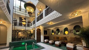 A spacious indoor area with a central pool, multiple seating areas, and a high ceiling with decorative lighting. - Riad L'Etoile D'Orient (Marrakech)