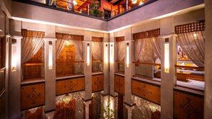 A multi-level hotel interior with a central courtyard, wooden paneling, and modern lighting. - Riad L'Etoile D'Orient (Marrakech)