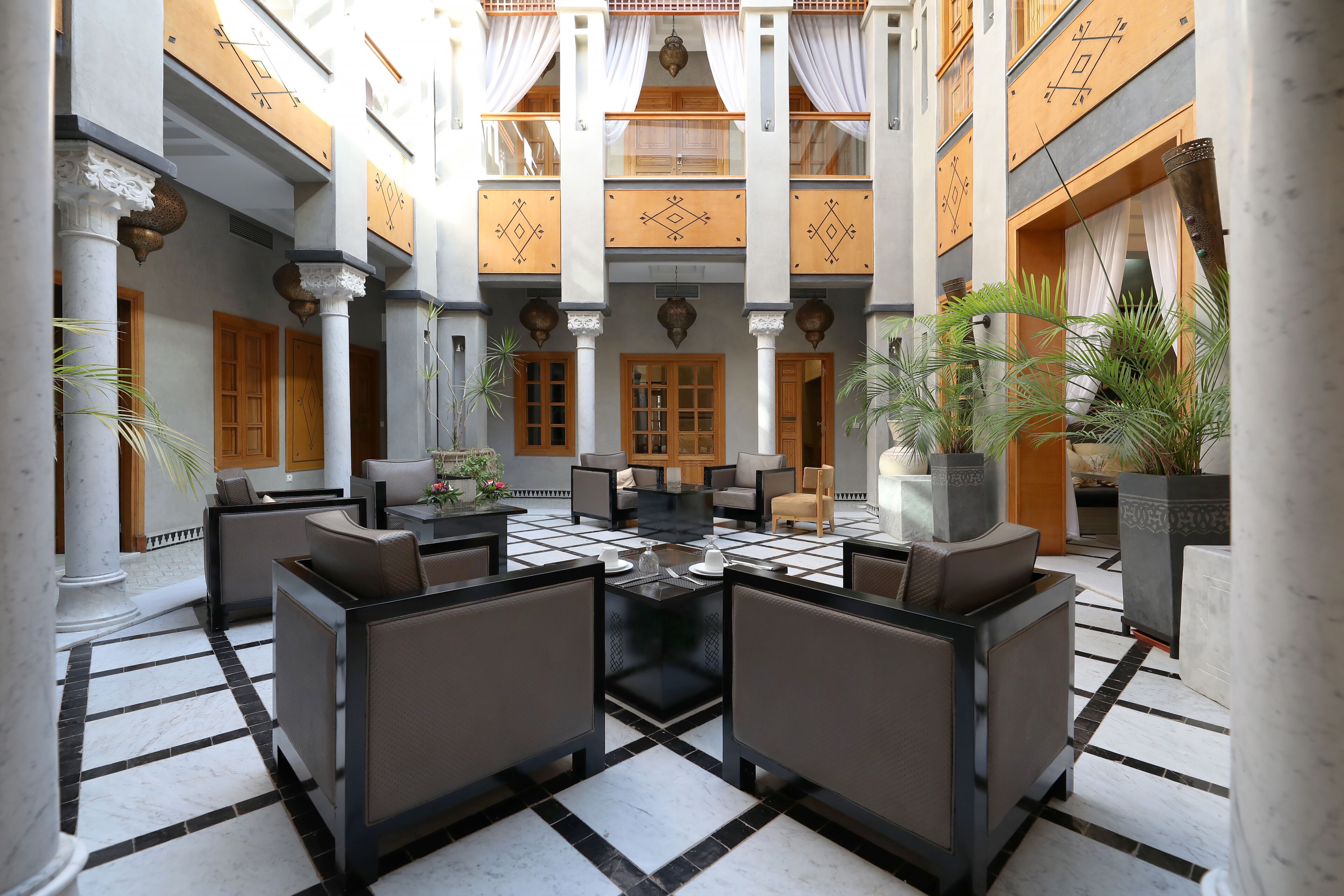 A lobby with a checkered floor, seating area, and columns.
