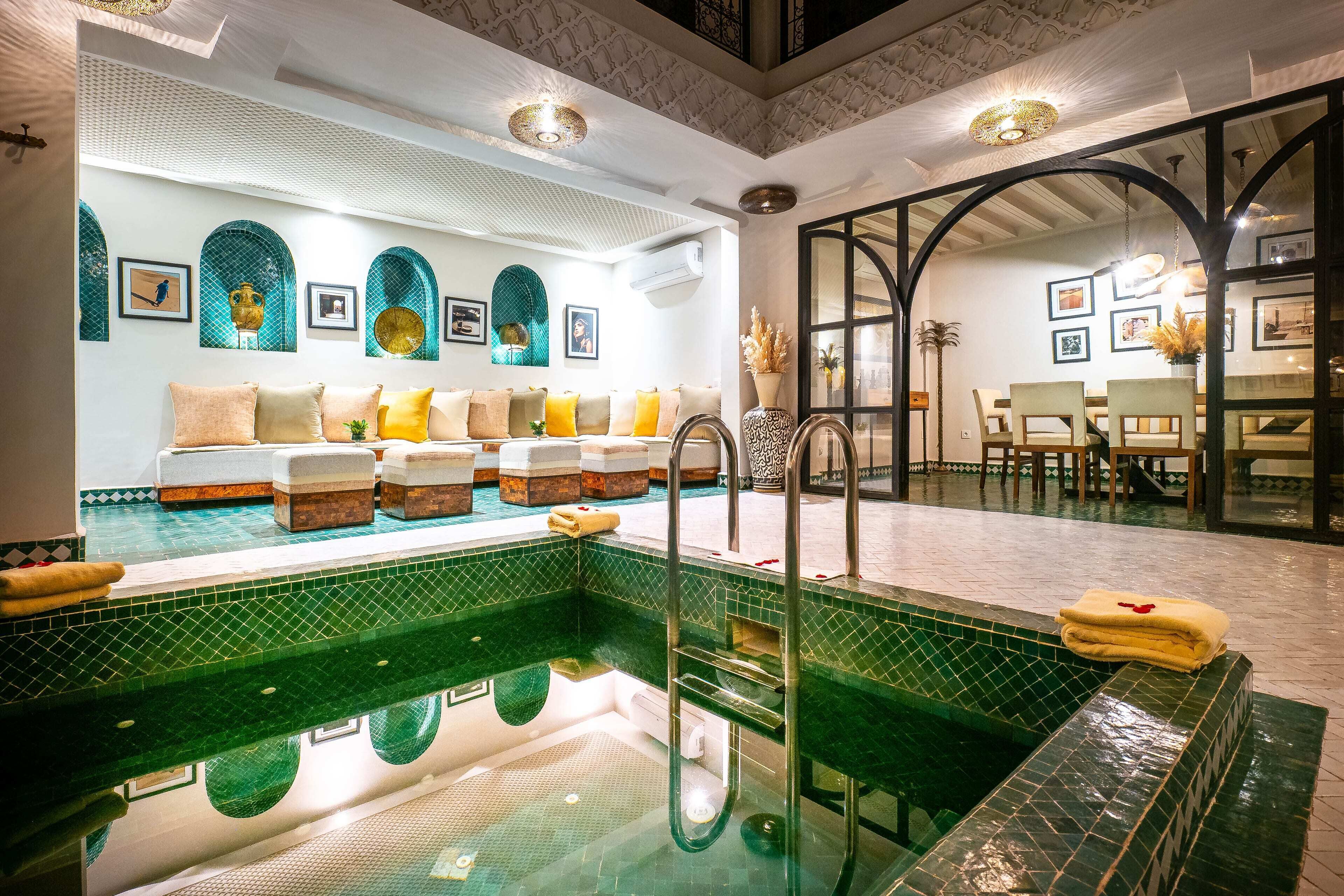 A hotel room with a pool, a dining area, and a view of the pool.