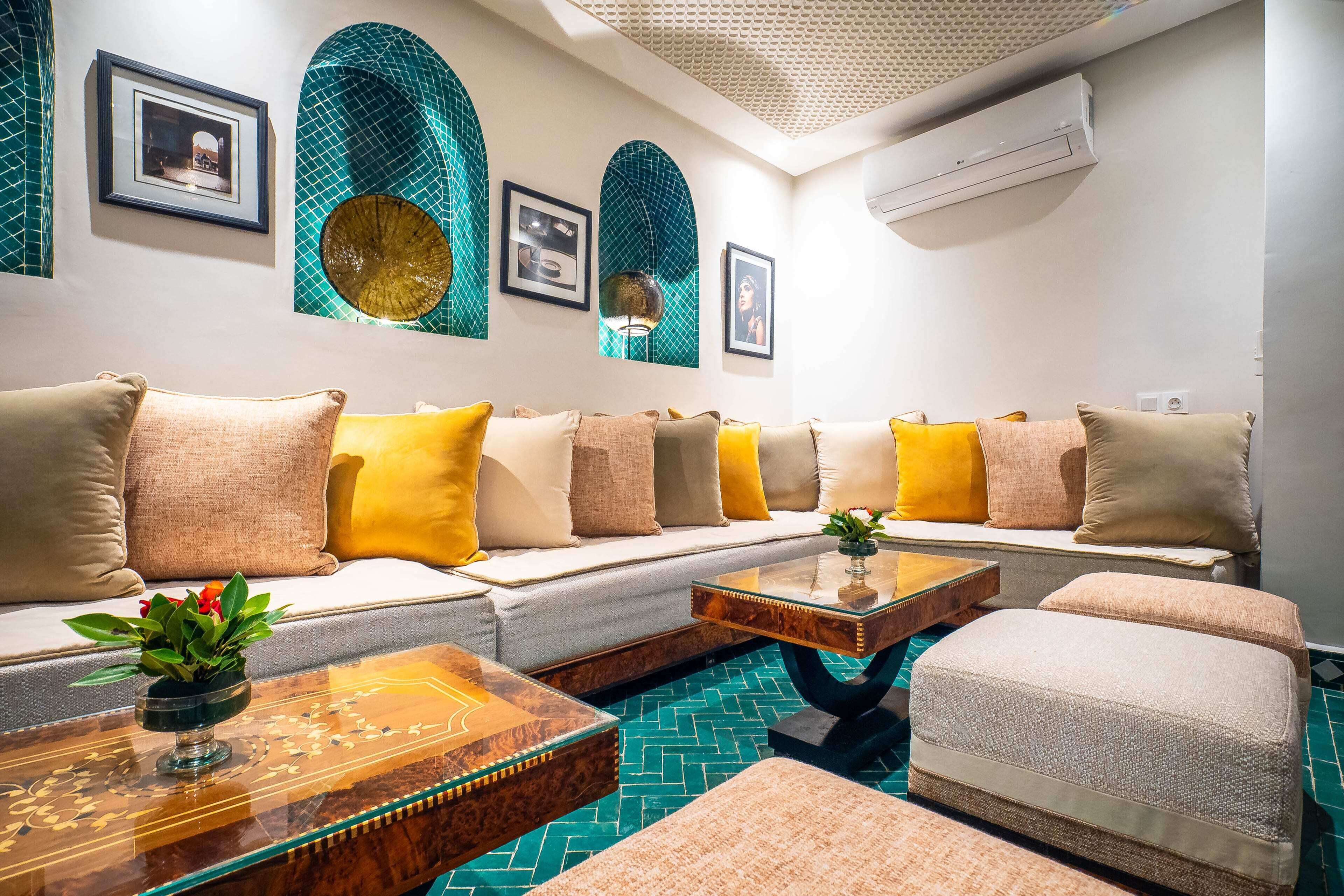 Una sala de estar moderna con un conjunto de sofá, almohadones decorativos, una mesa de centro y un piso con estampado.