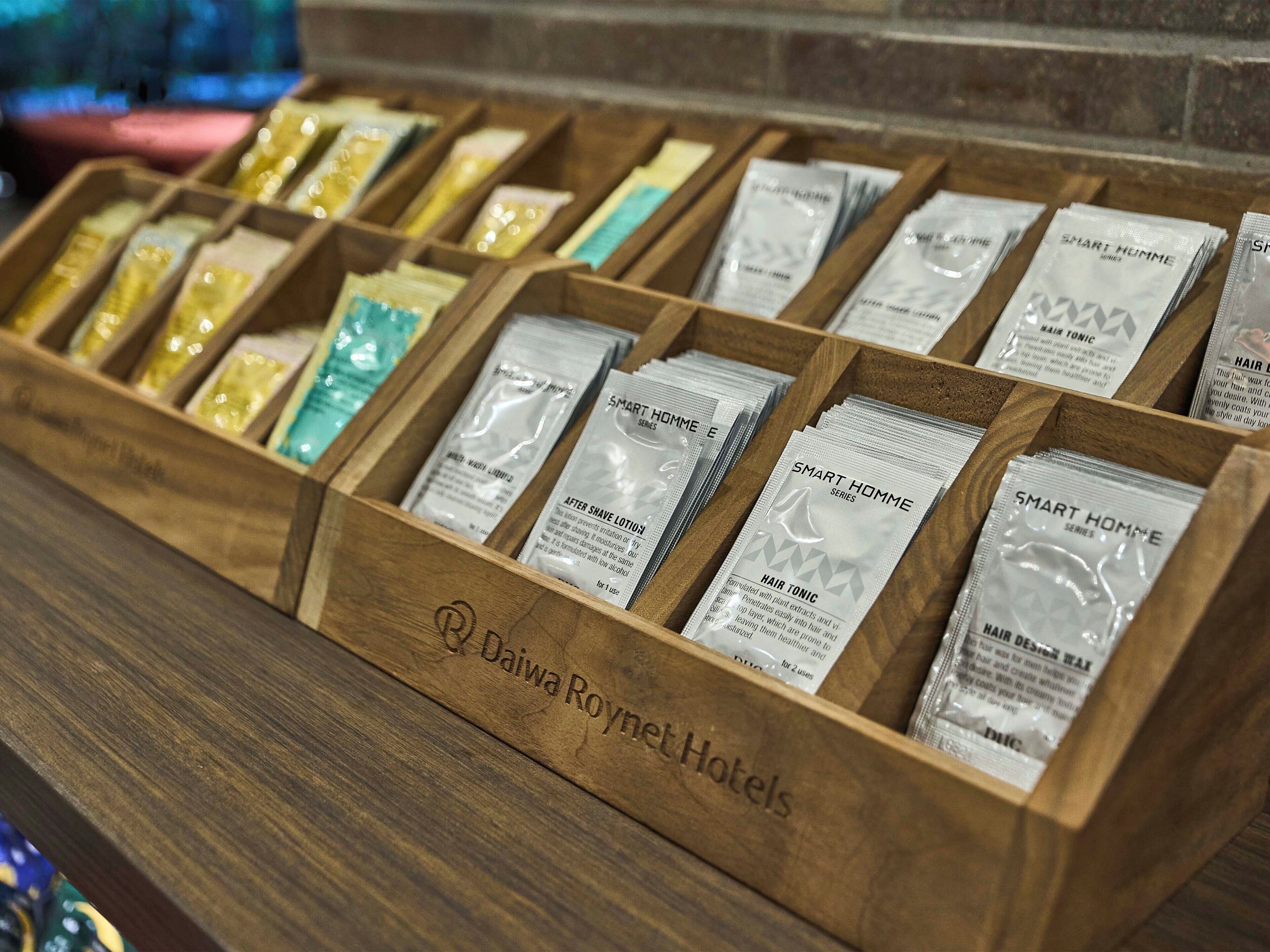 A wooden display case with various toiletries labeled 'Smart Homme' series, including aftershave lotion and hair tonic.