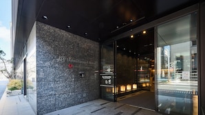 The exterior of the Daffwa Roynet Hotel with a modern facade, glass entrance, and a sign indicating 'Our Citizenship.'