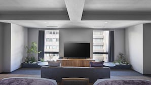 A modern living room with a flat-screen TV, a sofa, and a coffee table.