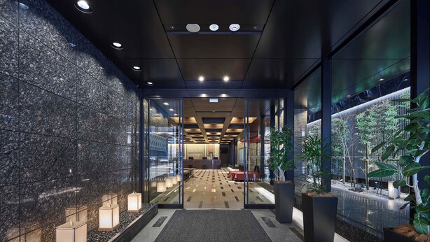 A modern hotel lobby with a reception desk, seating area, and potted plants.