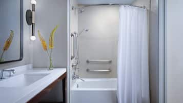 Un baño moderno con una bañera blanca, un lavabo doble y una ducha con cortina.