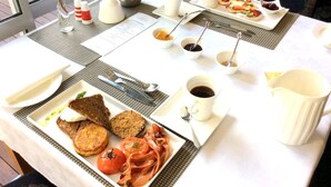 En morgenmadsbuffet med et udvalg af retter, herunder ristet brød, bacon, æg og frugt.