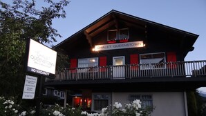 Hotellet Chalet Queenstown med balkon, skilt der viser udsolgt, og en gårdsplads med have.