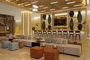A modern lobby with a seating area, wooden ceiling, and decorative vases.