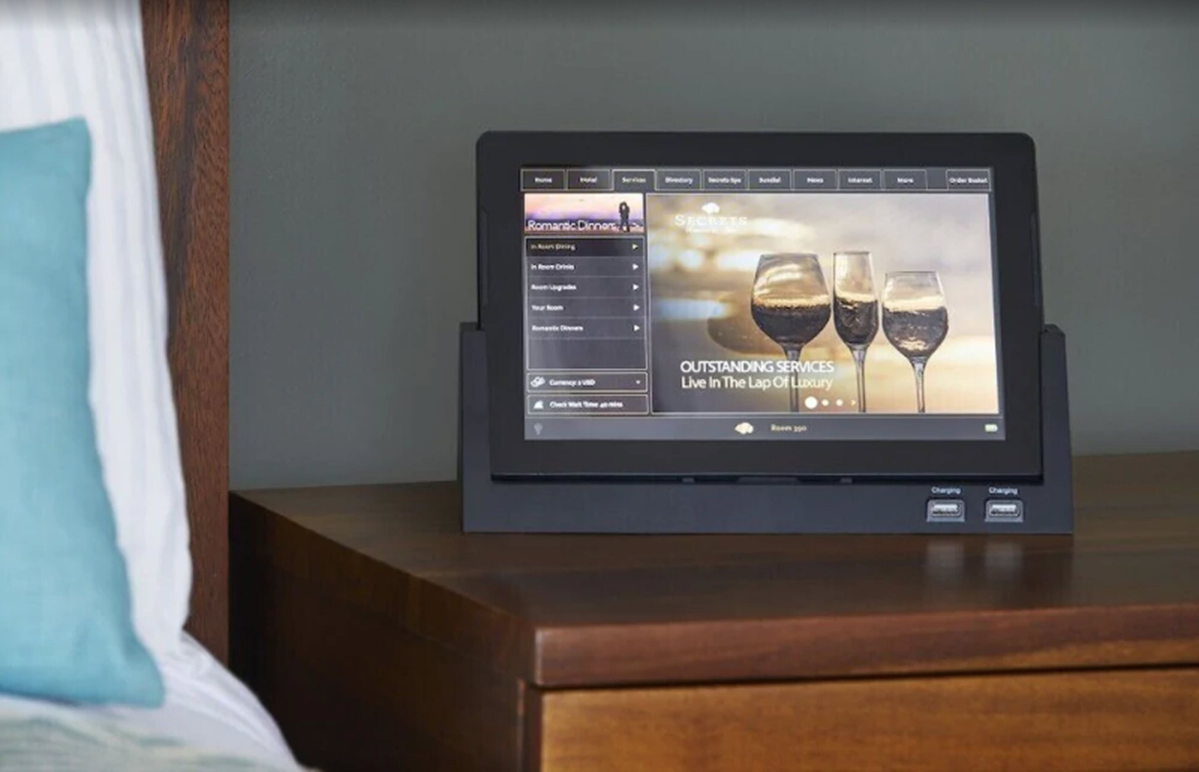 Een tablet waarop een menukaart wordt getoond, op een nachtkastje van hout.