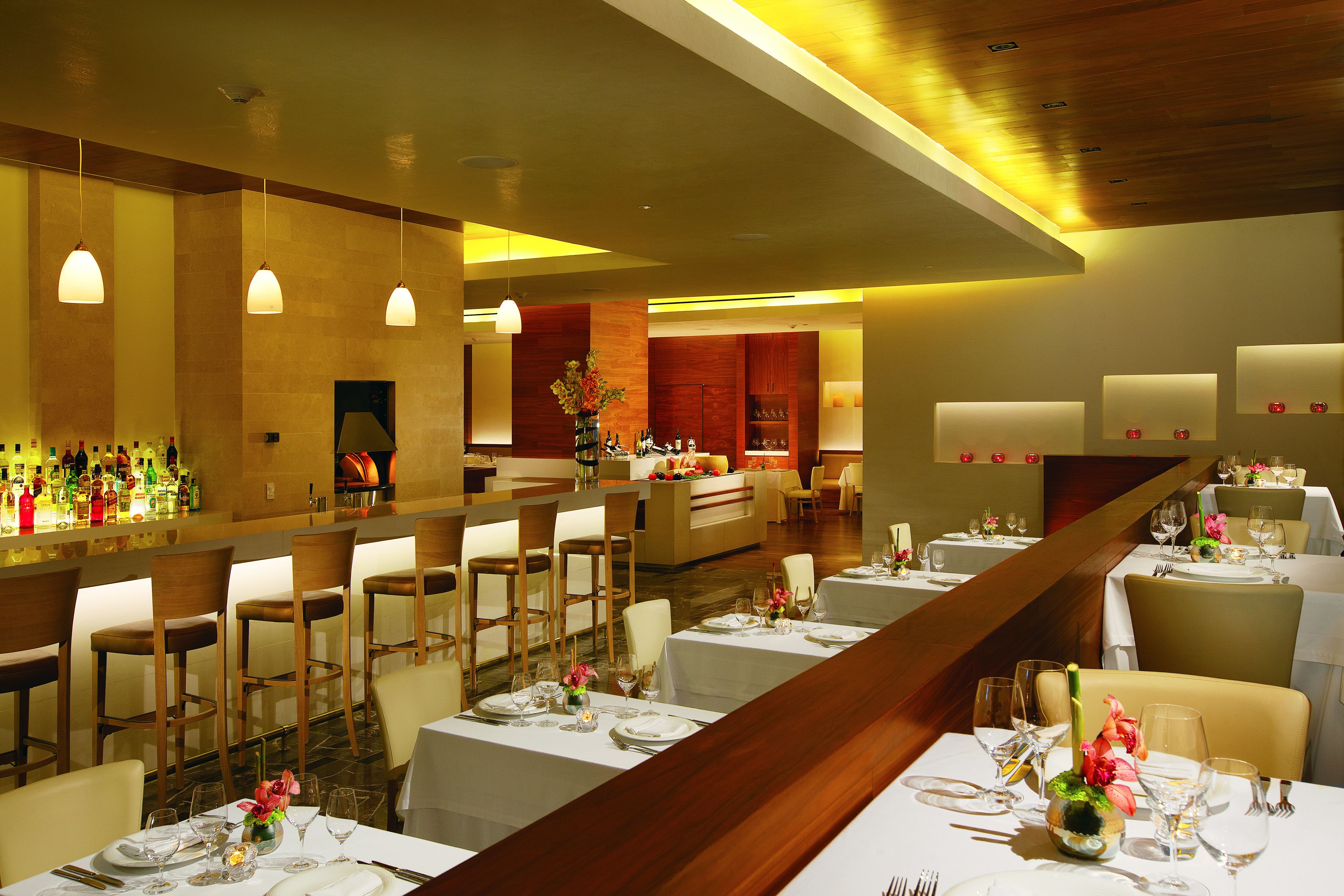 Un restaurant doté de plusieurs tables, de chaises et d’un bar.