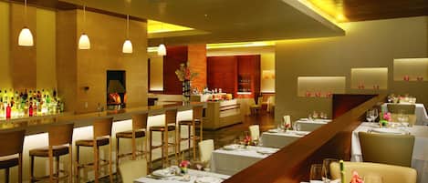 A restaurant with multiple dining tables, chairs, and a bar area.