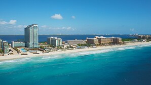 A coastal resort with high-rise buildings, beachfront villas, and a sandy beach. - Secrets The Vine Cancun - Adults Only - All Inclusive (Cancun)