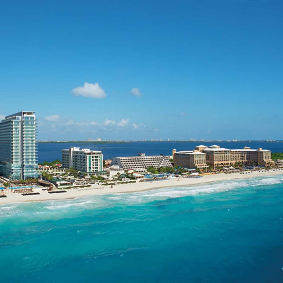 A coastal resort with high-rise buildings, beachfront villas, and a sandy beach.
