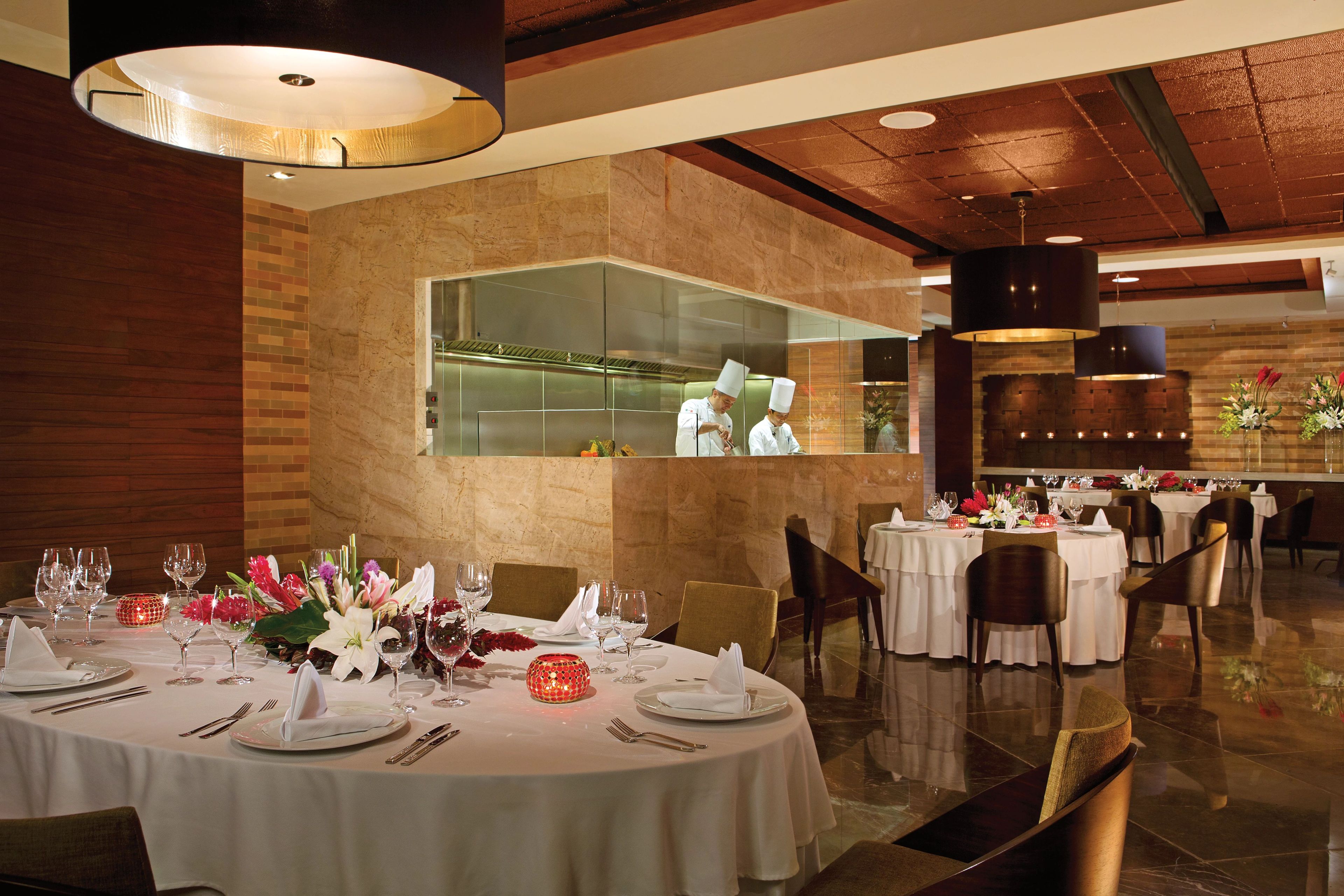 A restaurant interior with round tables, chairs, and a modern design.