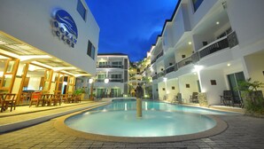A hotel courtyard with a swimming pool, outdoor seating, and multiple balconies. - Boracay Ocean Club Resort and Spa (Boracay Island)