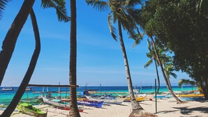 A beach with boats and palm trees. - Boracay Ocean Club Resort and Spa (Boracay Island)
