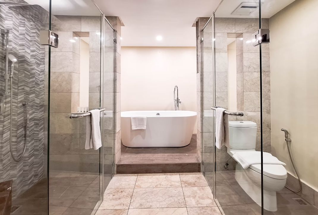 A modern bathroom with a glass-enclosed shower, a freestanding bathtub, and a toilet.
