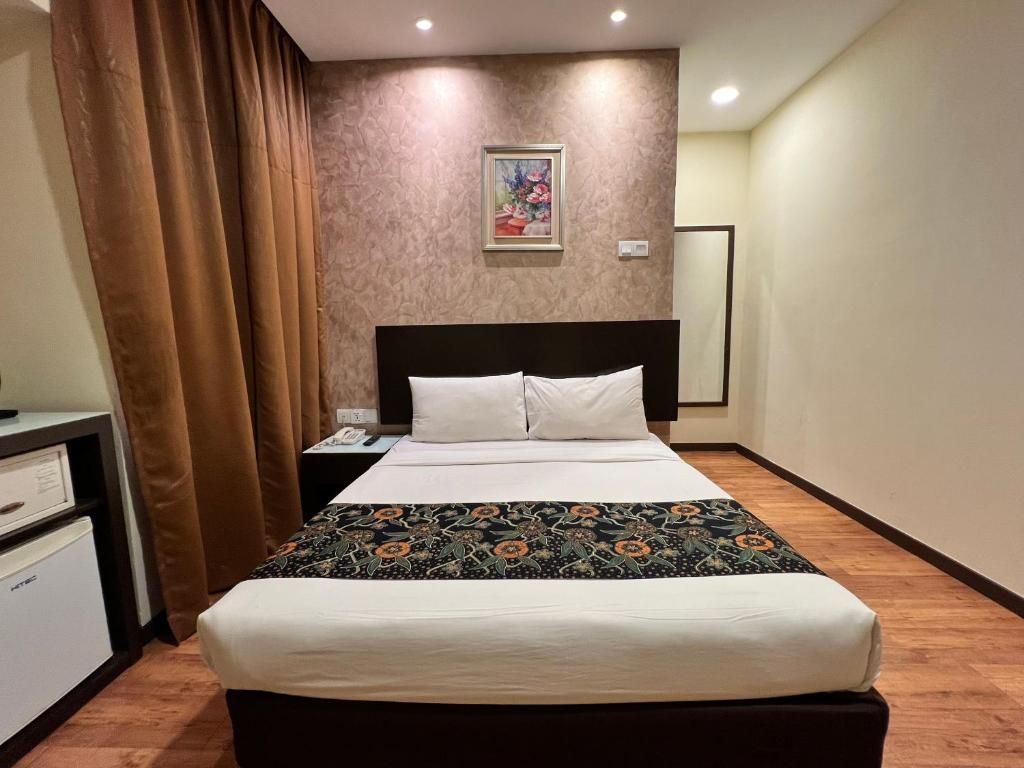A hotel room with a bed, a nightstand, a desk, and a wall-mounted painting.