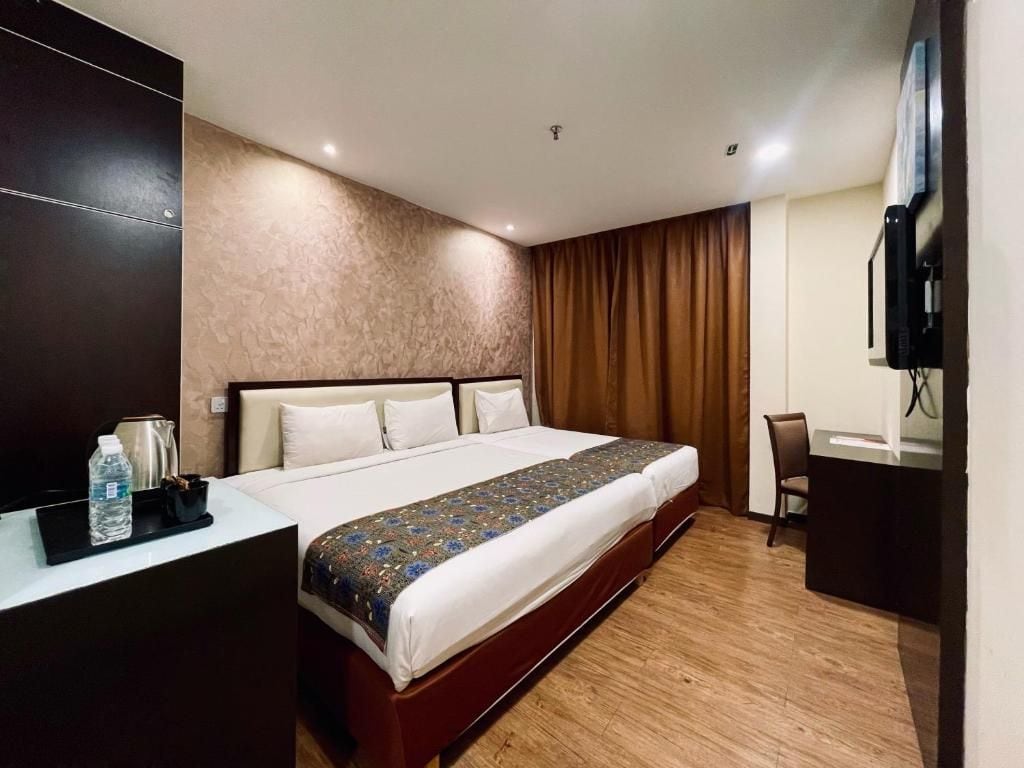 Una habitación de hotel con cama, escritorio, silla y televisor.