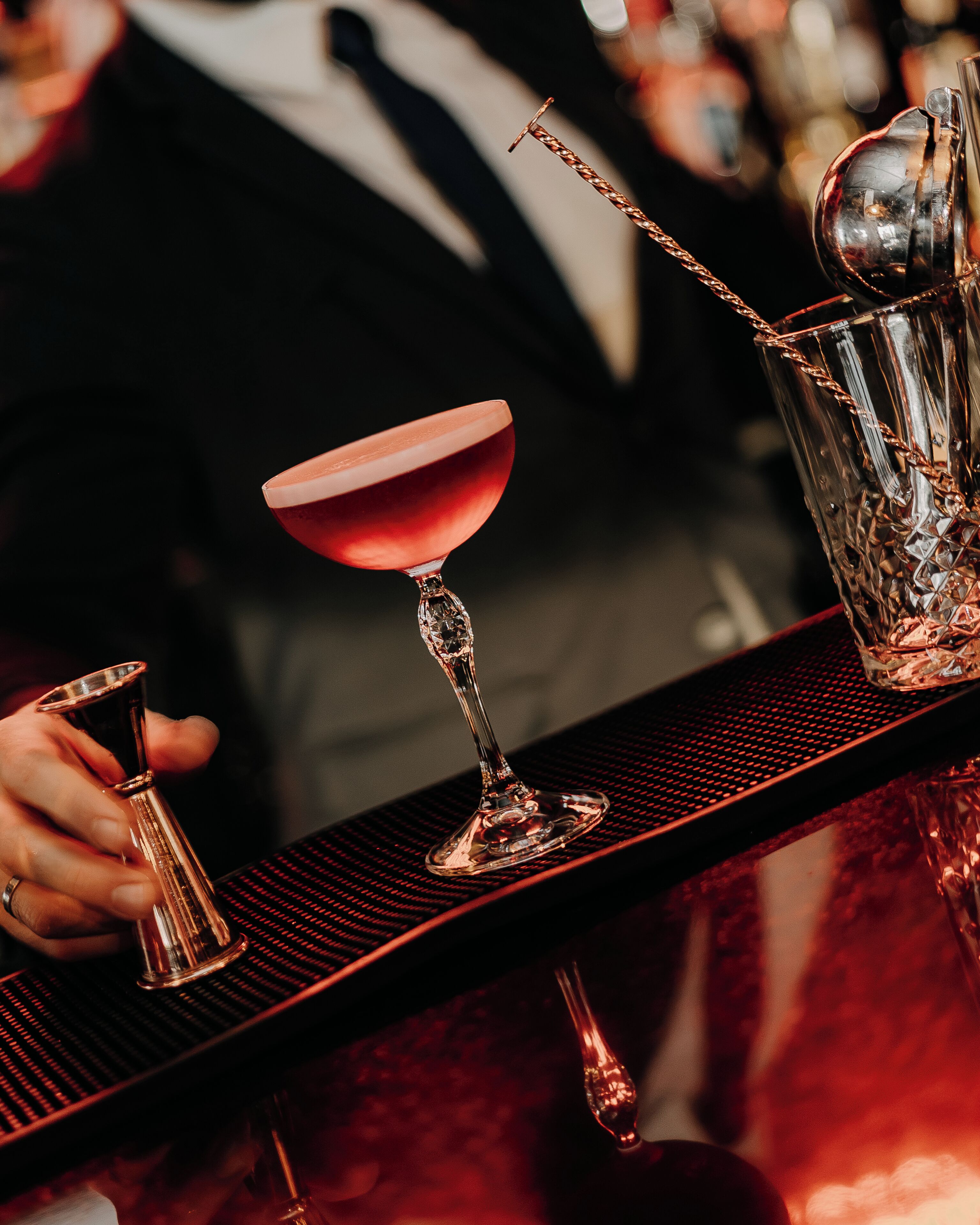 Une scène de bar avec un verre à martini, un shaker à cocktails et une cuillère à mélange.