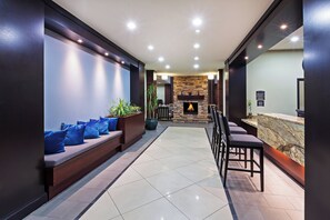 A modern lobby with a seating area, a fireplace, and a reception desk. - Staybridge Suites Amarillo - Western Crossing by IHG (Amarillo)