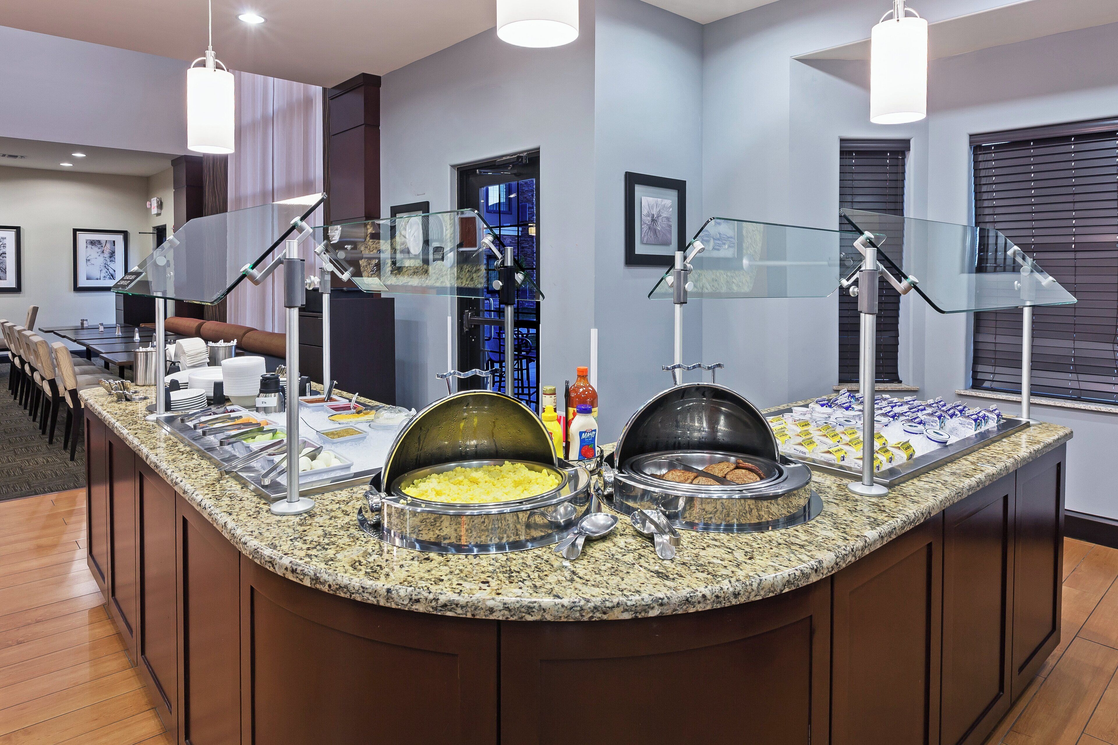 Un buffet proposant une variété de plats, avec un espace réservé aux convives en arrière-plan.