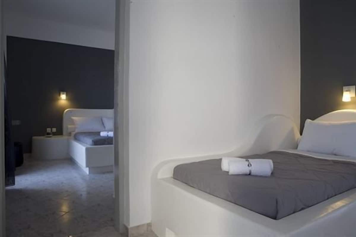 Une chambre à coucher moderne avec un grand lit, une table de chevet et une commode.