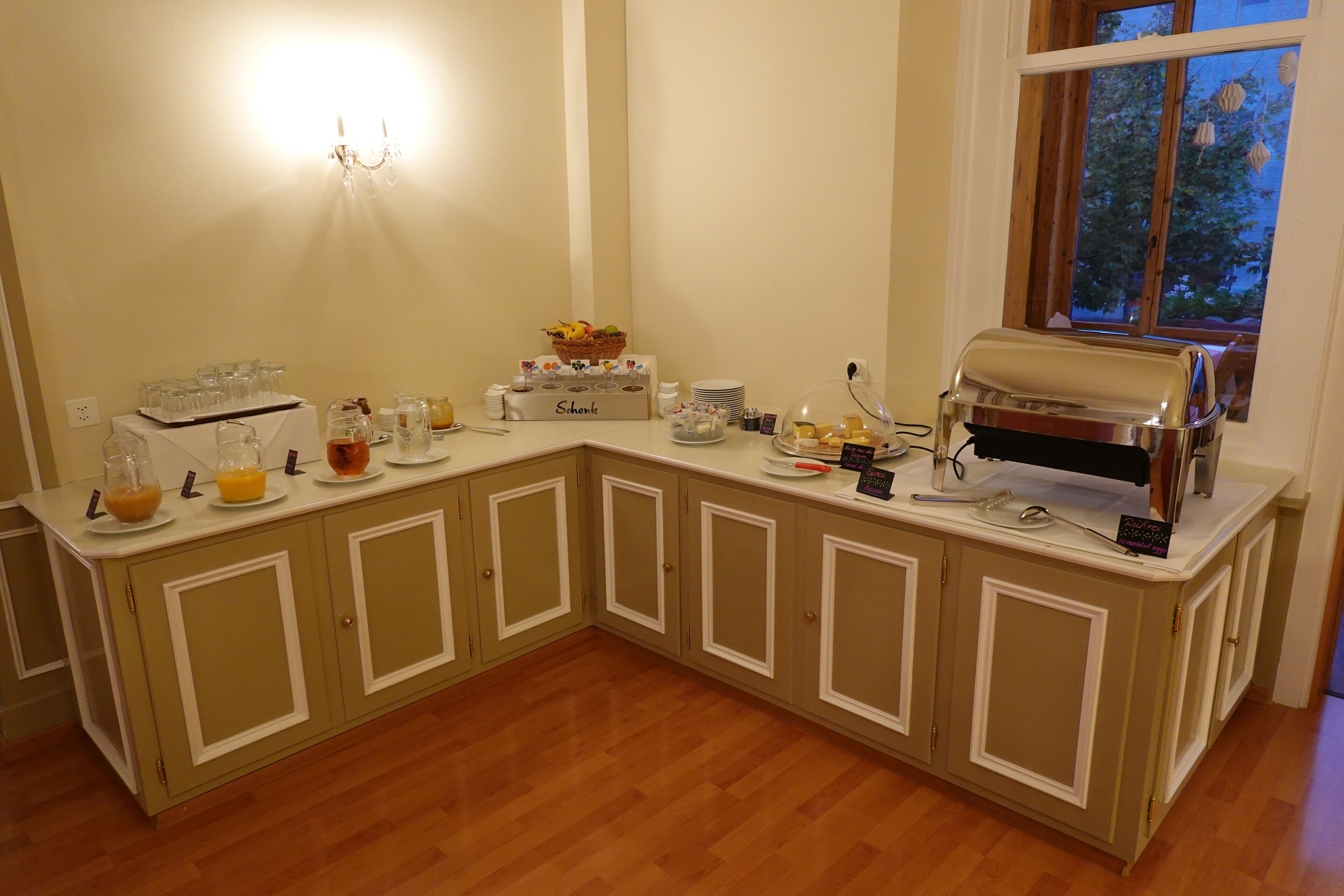 Una cocina con cafetera integrada, una cesta de fruta y servicio tipo bufé.