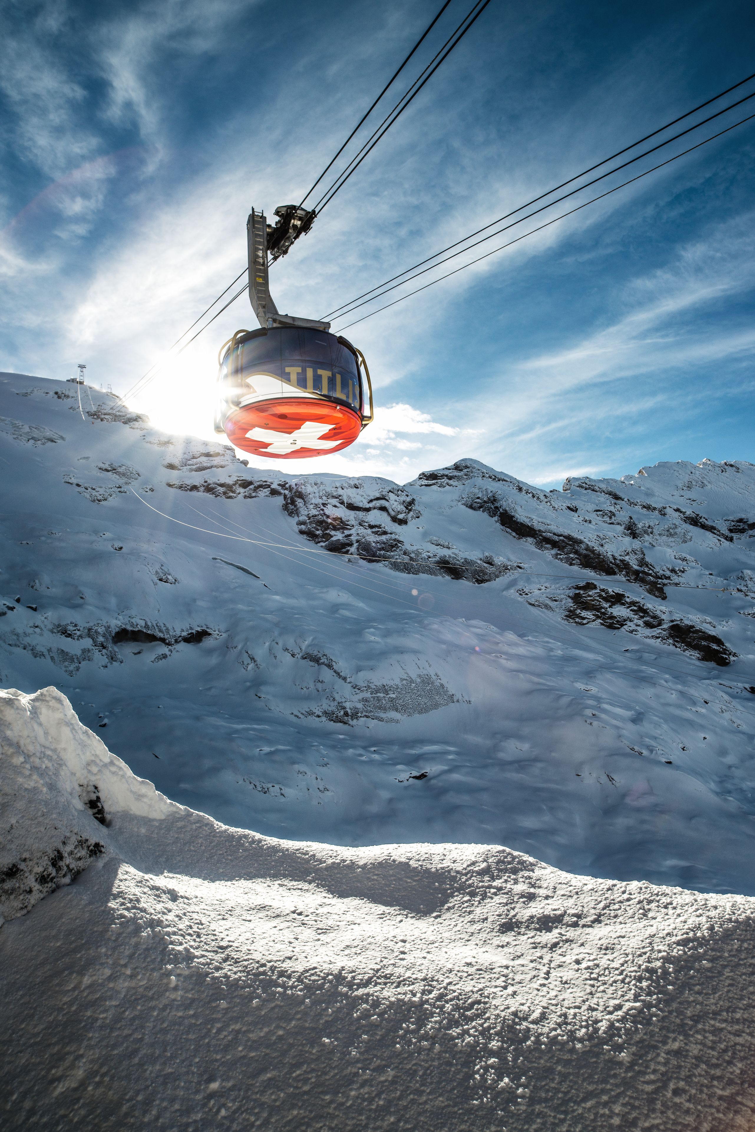 A chairlift ascending a snowy mountain slope.
