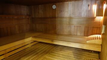Eine Sauna mit Holzbänken und einer Uhr an der Wand.