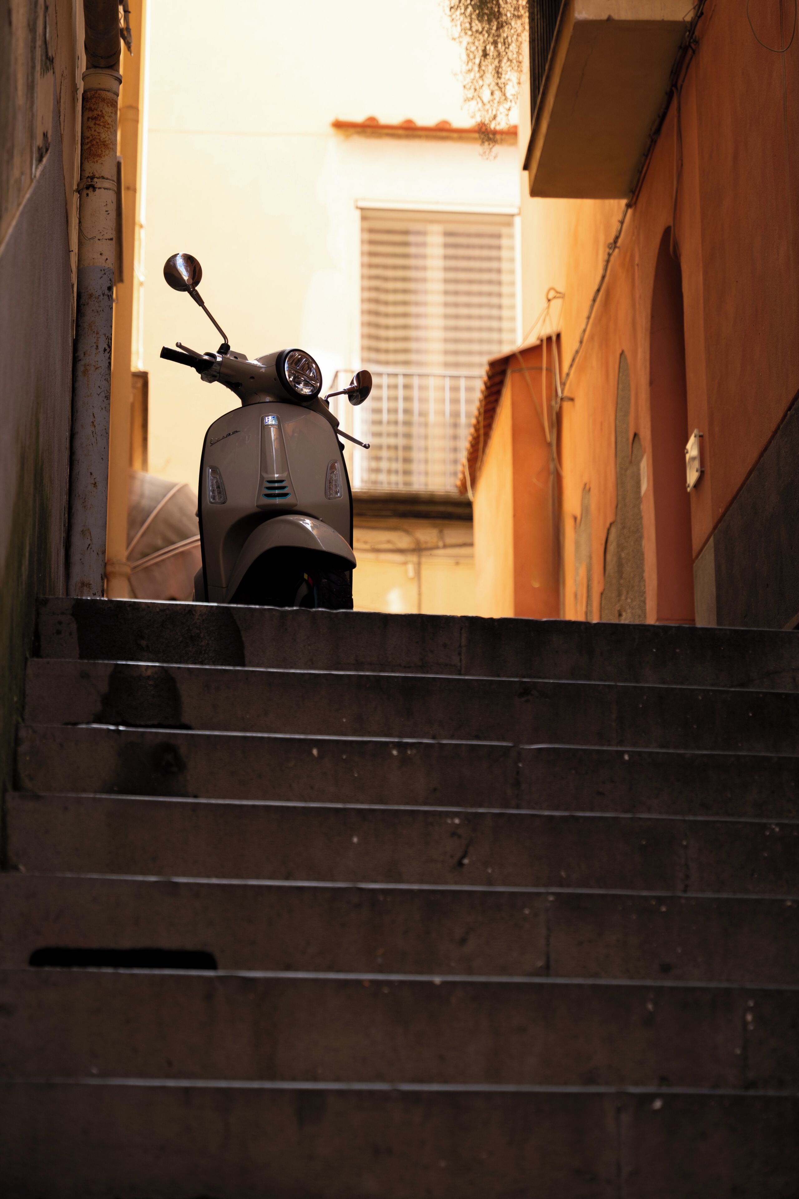 Un scooter était garé en haut d’un escalier en bois menant à un immeuble.