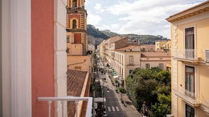 A street view with buildings, a bell tower, and a mountain in the background. - Palazzo Tasso (Sorrento)