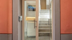 A modern entrance with a glass door, a staircase, and a number '33' sign on the wall. - Palazzo Tasso (Sorrento)