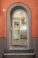 Una entrada moderna con puerta de vidrio, una escalera y un letrero con el número 33 en la pared.
