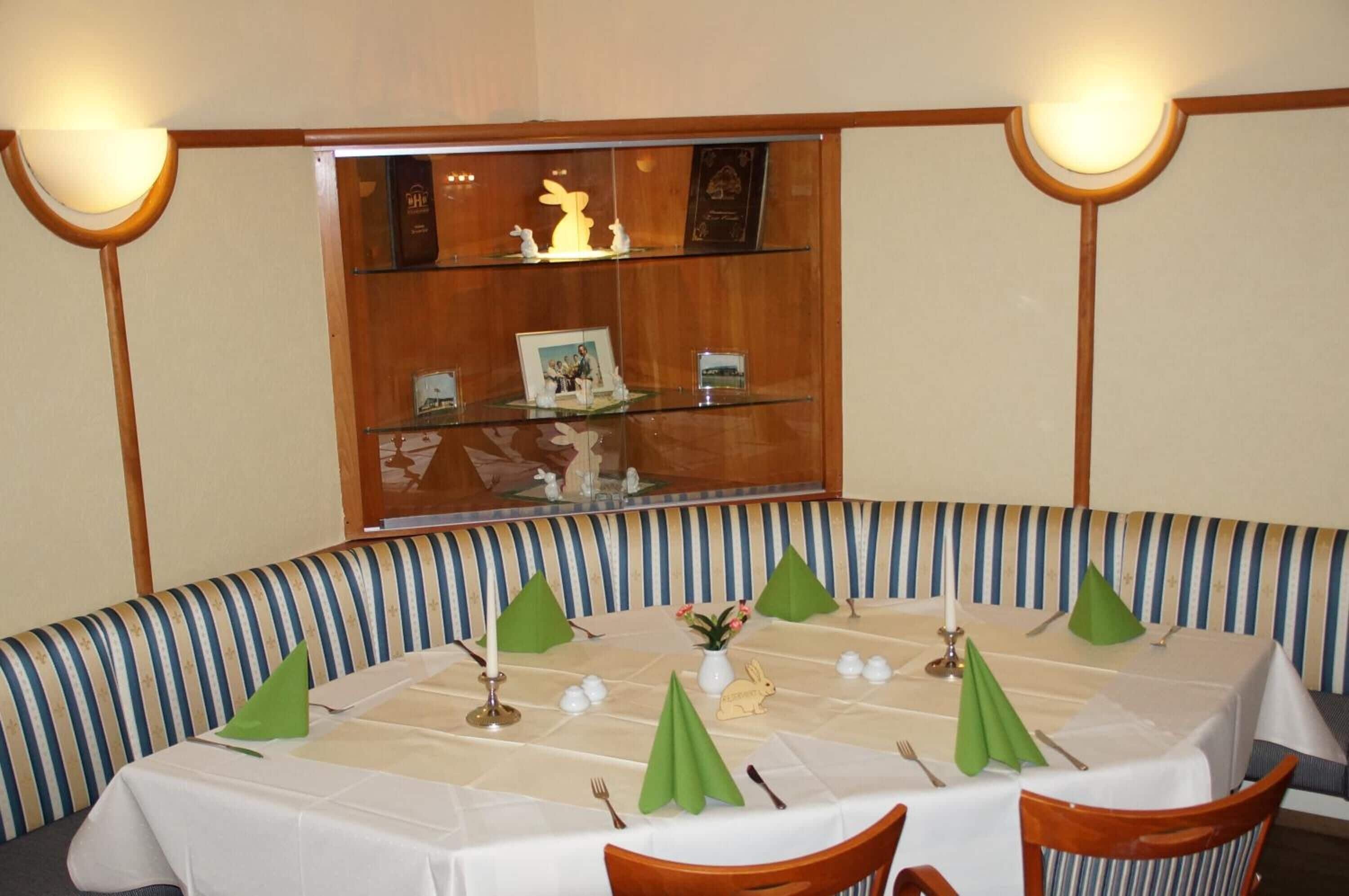 A dining area with a round table set for four, surrounded by striped benches.