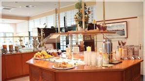 Un mostrador de buffet con diversos alimentos, una máquina de café y un jarrón decorativo.